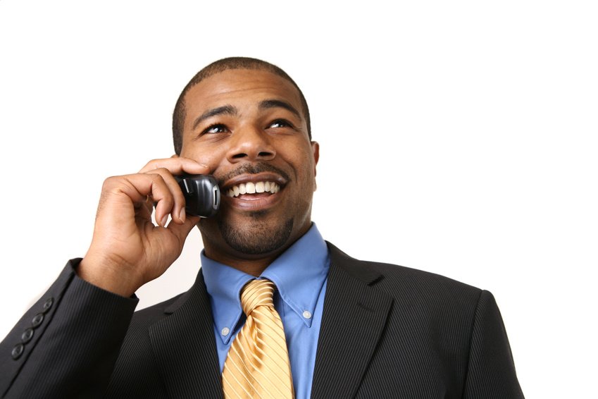 African American businessman talking on mobile phone, smiling. Close-up, isolated over white.